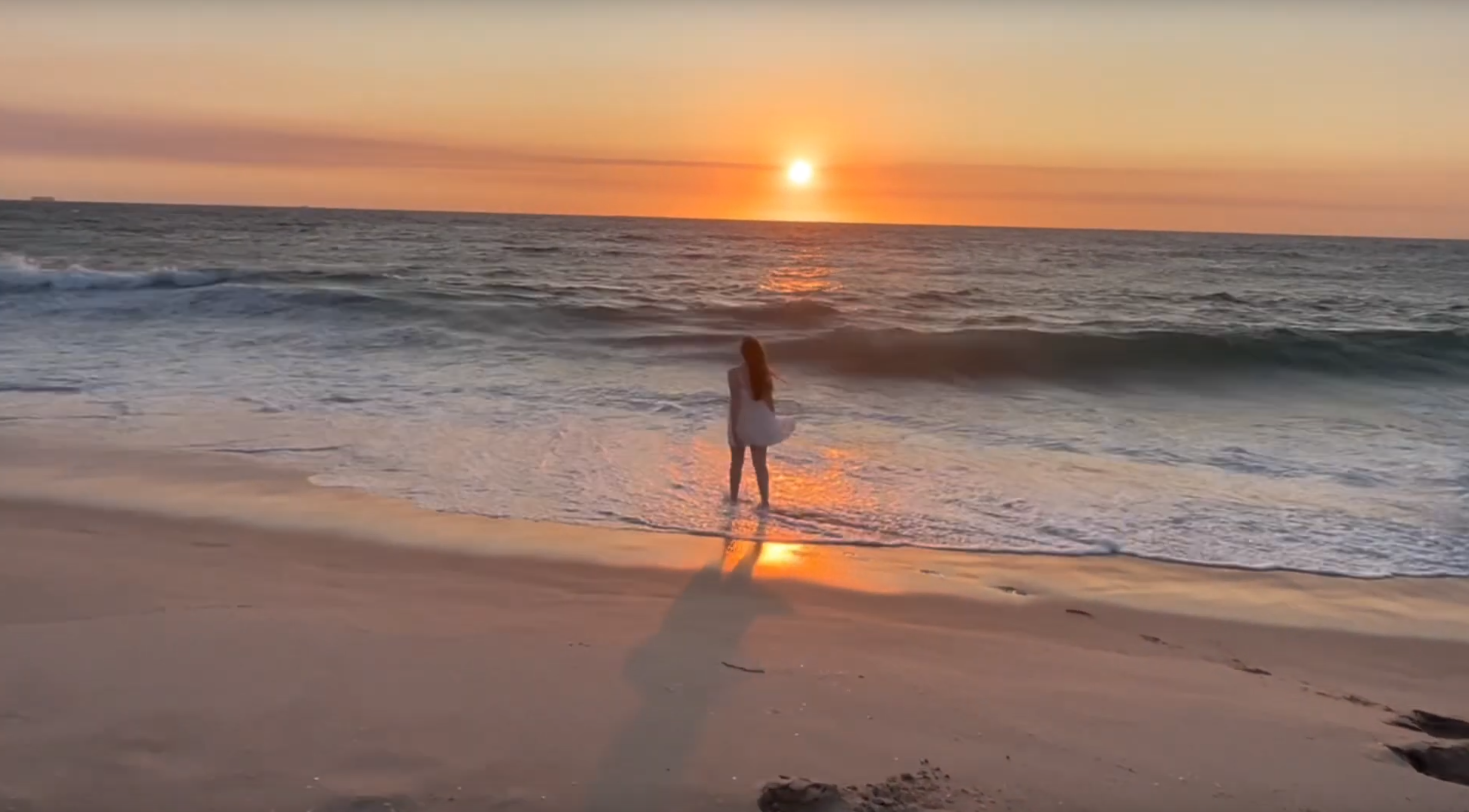Gabriella walking on the beach at sunset